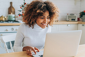 happy woman looking at computer screen