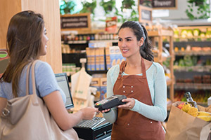 person shopping at a market using their credit card