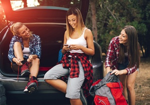 Women hiking, one using smartphone